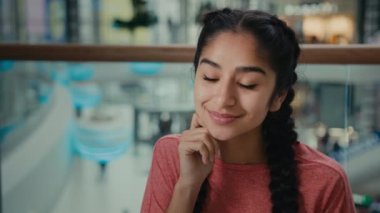 Çekici Arap kız öğrenci ziyaretçi kafe kafeteryasında rahatça oturur hafta sonunu alışveriş merkezinde sıcak içecek, gülümseyen bir kadınla geçirir aromalı kahve kapuçino içerek geçirir.