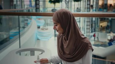 Halka açık Arap kafeteryasında temizlik yapan İslami öğrenci kız tesettürlü kadın. Koronavirüs bakterisinden antiseptik sıkan bakteri spreyi kullanın.