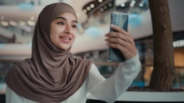 Müslüman kadın tesettürlü güzel kadın modern cihaz konuşma telefonuna bak internet üzerinden görüntülü sohbet Arap kız alışveriş merkezinden canlı yayın yapan blog