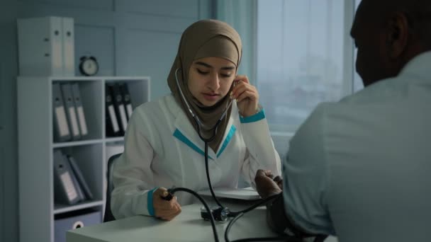 阿拉伯女医生护士用血压计测量高血压 心脏病患者的高血压听电脉冲老年男性心脏科检查 — 图库视频影像