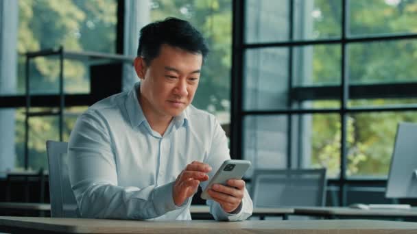 興奮した受賞者ビジネスマン成功した成熟したアジアの日本人韓国人中国人男性は驚きの収益性の高いオファーを獲得オンライン賭け読書携帯電話で良い通知は ビジネスの成功を喜ぶ — ストック動画