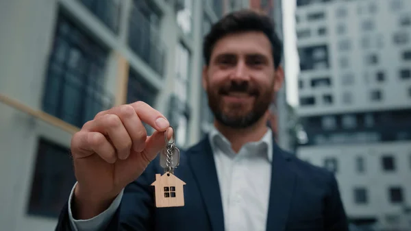 Estate agent businessman caucasian bearded man buyer tenant male hold keys from new house building rent housing apartment dwelling change home relocation commercial business deal lease flat in city