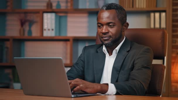 新しいビジネスコンピュータアプリケーションを使用してノートパソコンに入力してオフィスで働くアフリカ系アメリカ人ビジネスマンに焦点を当て幸せな男クライアント親指を示すサービスに満足ジェスチャー承認契約サイン — ストック動画