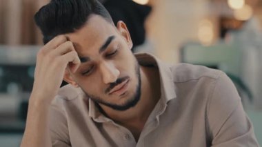 Gergin Hintli etnik erkek, erkek işadamı, baş ağrısı çekiyor, stres yaşıyor, iş sorunları, aşırı çalışma, yorgun çalışanlar derin sorunların çözümünü düşünüyor, üzülüyor.