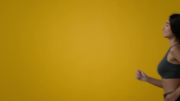 Side View Empty Cope Space黄色のスタジオの背景インドのスリムエスニック強いスポーティな女の子運動選手ランナージョガー女性ランアクティブランニングジョギングフィットネススポーツワークアウト減量ボディケア — ストック動画