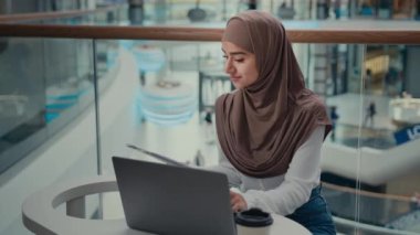 Arap Türkçe Müslüman kadın öğrenci İslami iş kadını tesettür işkadını laptopta uzak çalışma ticari doküman belgeleri elektronik veri ödeme faturalarını çevrimiçi e-ticaret