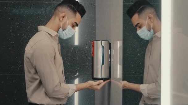 机场公共场所公司Wc洗衣店一名戴着医疗面罩的商人 用自动酒精清洁剂肥皂凝胶自动抗菌分配器洗手 Covid 19预防 — 图库视频影像