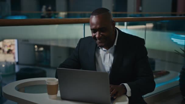 在购物中心公司工作的中年男人 带着笔记本电脑 在网上谈论视频电话会议打字 非洲商人与计算机雇主一起使用网络摄像头应用程序 — 图库视频影像