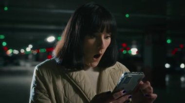 Şok olmuş bir şekilde telefon ekranına bakan duygusal bir kadın akıllı telefonlu bayan iş kadınında şok edici bir şekilde şaşkınlık dolu bir ifade var.