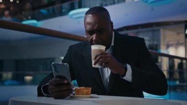 Afrika 'da orta yaşlı bir adam. 50' li yaşlarında düşünceli işçi. Ciddi işadamı. Kafe masasında oturan, kahve içen, çay içen, akıllı telefon uygulaması kullanan bir girişimci.