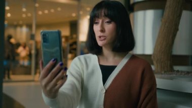 Akıllı telefonlu web kamerası olan kadınla olumlu konuşarak alışveriş merkezinin içinde el sallayan bir video görüşmesi yaptı. Merhaba, selamlayıcı kız.
