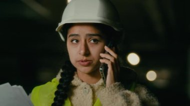 Arap kadın teknik mühendis kadın mimar müteahhit müteahhit üniformalı miğfer şefi cep telefonuyla inşaat kontrol mühendisliği ile ilgili iş sözleşmesi planını tartıştık.