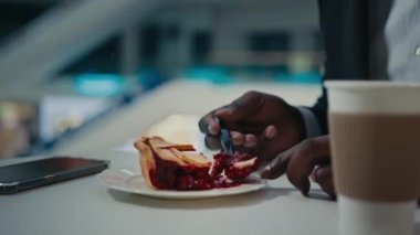 Pasta fırınının huzurunu yakın. Resmi takım elbiseli tanınmaz bir adam. İş adamı, kahve fincanı ile kafeterya masasında yemek yiyor.