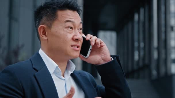 アジアのエージェント中年ビジネスマン40代の雇用主の起業家の答えコール屋外大人の上司マネージャー正式な男は 市内での遠隔遠隔話仮想会話モバイル通信で呼び出します — ストック動画