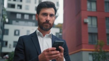 Profesyonel iş adamı, 30 'lu yaşlarda, iş adamı şehir merkezinde, internet üzerinden sosyal ağlarla sohbet ediyor mobil uygulamalar kullanıyor, SMS dijital iletişim modern teknoloji kavramını okuyor.