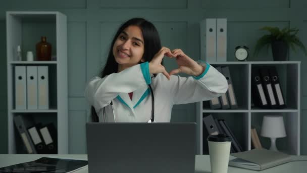 誠実な若い女性アラビア語ラティーナ循環器内科医学生循環器内科医は愛のシンボルを作る心臓器官の形は 人間の寛大さのケアサポート慈善寄付の概念を実証 — ストック動画