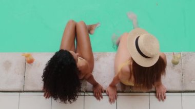 Mavi gök mavisi suyu sıçratan çıplak ayaklı kadın sevgililer yazlarını deniz tatil beldesi sahil bayanlarında su altında bacaklarını sallayarak geçirirler. Mayolu, bronzlaşmış, seksi modellerin rahatlatıcı manzarası.