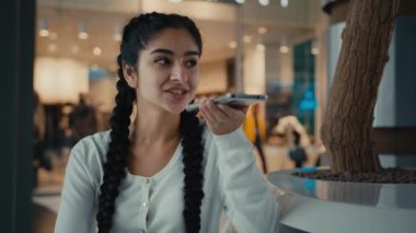 Genç Arap kadın alışverişçi hoparlörden sesli konuşma kaydı gönderdi. Ses uygulamasını etkinleştirdi. Kadın iş kadınının telefon bağlantısını çevrimiçi olarak konuşmasına yardımcı oldu.