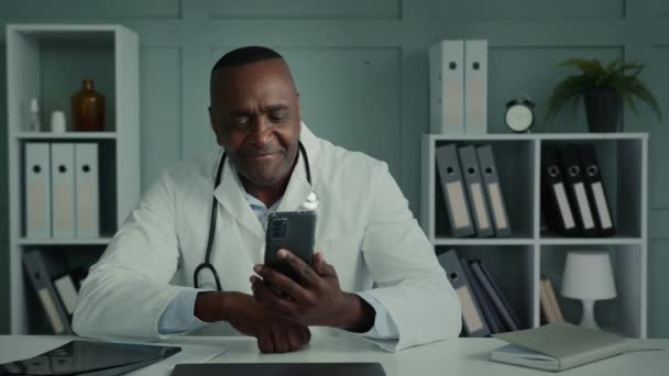 Africano Médico Homem Meia Idade Trabalhador Usar Celular Gadget Mensagem — Vídeo de Stock