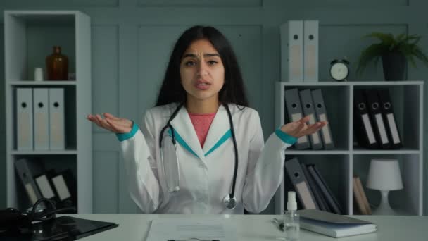 医生女性医务工作者在线与病人交谈使用视频会议耸耸肩不知道答案不确定困惑的医生对健康诊断的怀疑不确定的立场 — 图库视频影像