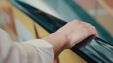 Alışveriş merkezinde yürüyen merdivenin korkuluklarını tutan erkek eli kapatın. Tanımlanamayan girişimci işadamı, havaalanındaki metro istasyonunda merdivenleri çıkarken tırabzan tutuyor.