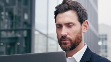 Yakın plan başarılı odaklı adam bilgisayarlı ekran profesyonel iş adamına bakıyor çevrimiçi açık havada çalışıyor sosyal ağlara bakıyor internet üzerinden müşteriyle iletişim kuruyor iş projesi yaratıyor
