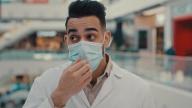 Etnik yorgun Hintli doktor erkek terapist. Laboratuvar cerrahı. Üniforma giymekten yorulmuş.