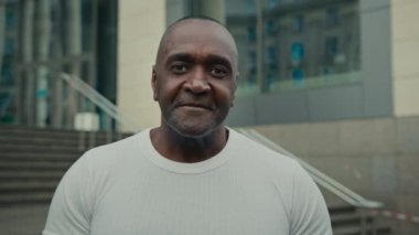 Etnik orta yaşlı yetişkin yetişkin, 50 'li yaşlarda, Afro-Amerikan iş danışmanı, açık havada kameraya bakarak gülümsüyor. İşadamı 40 'lı yılların girişimci broker şirketinin CEO portresi