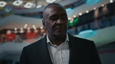50 'li yaşlarda, etnik orta yaşlı, erkek finans danışmanı Afrikalı işveren, iş hırsını düşünüyor. Dalgın bir şekilde etrafa bakıyor, kahve içiyor, çay komisyoncusu, düşünceli bir iş adamı gibi düşünüyor.
