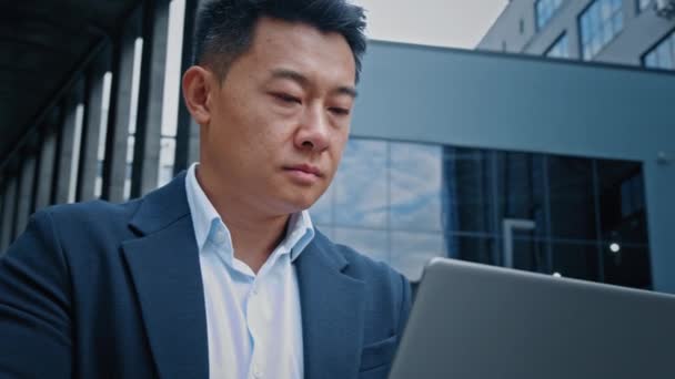 インターネット企業アプリでデータを分析するオンラインプロジェクトスタートアップで忙しいシリアスマネージャーのボスリーダー企業Ceo韓国人40代の中高年ビジネスマン起業家男性はノートパソコンで作業 — ストック動画