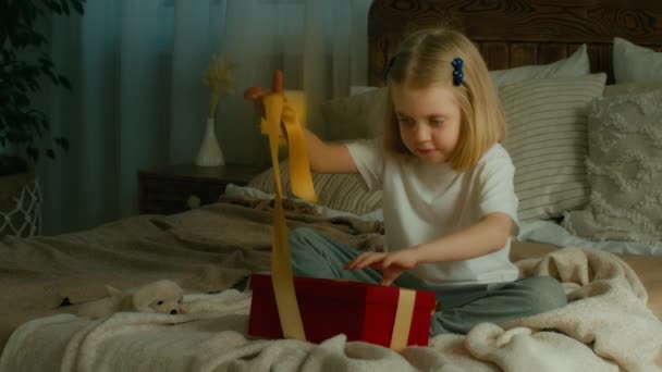 小女孩躺在床上 打开包装 打开圣诞礼物盒 与错误的不想要的礼物混淆在一起 不满意里面空空如也的包裹 — 图库视频影像