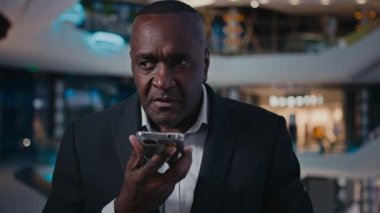 50 'li yaşlarda cep telefonuyla konuşan bir girişimci. İş görüşmeleri. Sesli mesajlar.