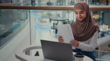 İş kadını Arap İslamcı kadın, iş sözleşmesi kağıt raporunda çalışıyor. Belgeler, bilgisayarın mali denetim mesafesinde veri girin. Online bankacılık uygulaması e-ticaret faturaları ödeniyor.
