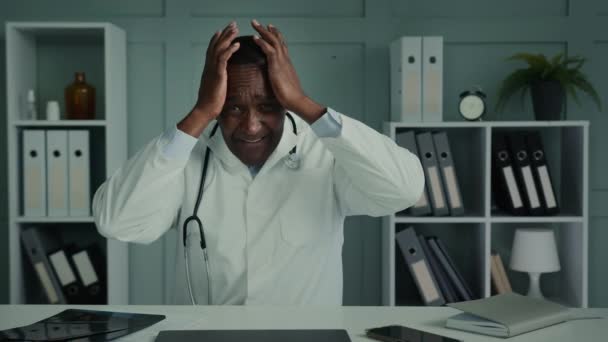 紧张的男医生绝望的悲伤的非洲老年外科医生担心职业错误的男人疲倦的男医生感到内疚或头疼的想法忧郁的想法 — 图库视频影像