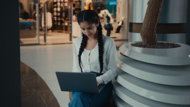 아라비 Latina 대여성 쇼핑센터에서 일하는 여성은 노트북 브라우징 사이트를 이용하여 — 비디오