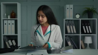 Doktor hemşire genç doktor. Klinik masasında çalışan doktor. Günlük çalışmaya başla. Kağıt belgelerini düzenle.