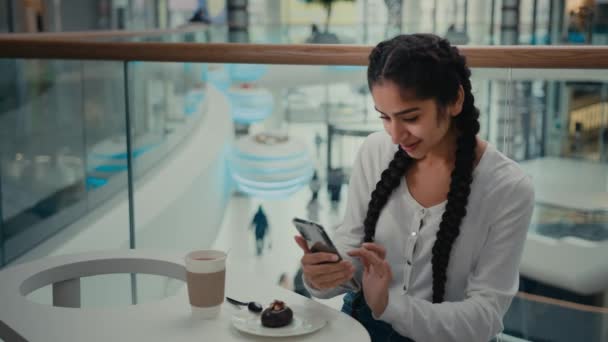 女性フードブロガー創造的な若いアラビア系インド人女性スタイリッシュな女の子のトレンディーな写真家はカフェメディアブログで携帯電話で写真を撮るおいしい朝食コーヒーとチョコレートケーキを撮る — ストック動画