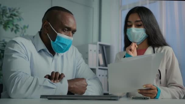 Arzthelferin Schutzmaske Bietet Kranken Afrikaner Bei Vorsorgetermin Gespräch Mit Alter — Stockvideo
