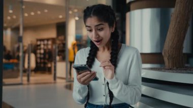 Genç İspanyol kadın etnik iş kadını öğrenci heyecanlı kadın kullanıcı indirimleri kazandı cep telefonu işi başarısı iyi haberler aldı zaferi online olarak kutlayın yeni akıllı telefon