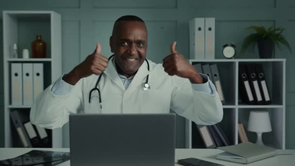 情绪愉悦的男医生白衣医生牙医全科医生心脏科医生非洲男子推荐医疗保健药物健康疫苗做大拇指举手势认可好结果 — 图库视频影像