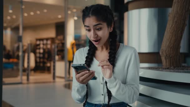 若いヒスパニック系の女性民族の女の子のビジネス女性学生興奮した女性のユーザーは 携帯電話のビジネスの成功に割引を獲得成功は良いニュースを受け取る勝利を祝うオンライン利益新しいスマートフォン — ストック動画