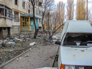 Kharkiv, Kharkov, Ukrayna - 05.07.2022: Rus işgalinin Ukrayna şehirlerine düzenlediği soykırım bombalı saldırı sonucu yıkılan araba hurdası, metal enkaz ve yanan ev binası