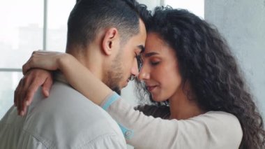 Yakın plan mutlu eş, kocaya sarılır boyun eşlerine, kucaklaşır kucaklaşır. Romantik, çok ırklı evli çift kucaklaşıp kucaklaşıyorlar. Alınlarına dokunuyorlar. Evlilik yıldönümü tarihleri.