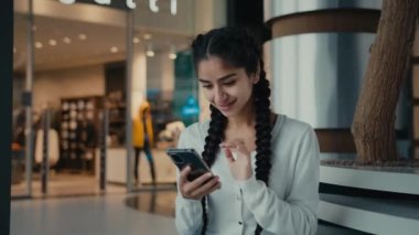 İş kadını İspanyol genç kadın internet üzerinden alışveriş yapıyor internet mağazasına mesaj yolluyor Wi-fi teknolojisiyle uzaktan iletişim kurarak cep telefonu bağlantısı kuruyor.
