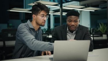 İş adamı Afrikalı avukat akıl hocası, bilgisayar işinde çalışan Hintli erkek müşteriye online iş yazılımları hizmetlerini açıklayan müşteriye yardımcı oluyor. Etnik erkekler, dizüstü bilgisayar ofis toplantısına bakıyor.