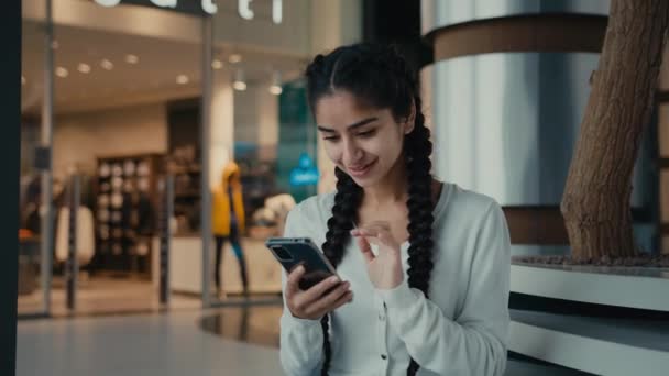 ビジネス女性のヒスパニック女性若い女性は インターネットストアのテキストメッセージを閲覧し 携帯電話のショッピングを保持します — ストック動画
