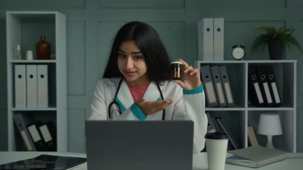 女医生阿拉伯妇女交谈视频会议使用电脑应用程序显示药瓶与药物药丸从疾病解释处方在线咨询推广药物治疗药学概念 — 图库视频影像