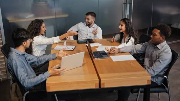 Successful multiethnic colleagues discussing idea project in office boardroom meeting. Multiracial business team group of people discuss talking brainstorm managers workers partners working teamwork
