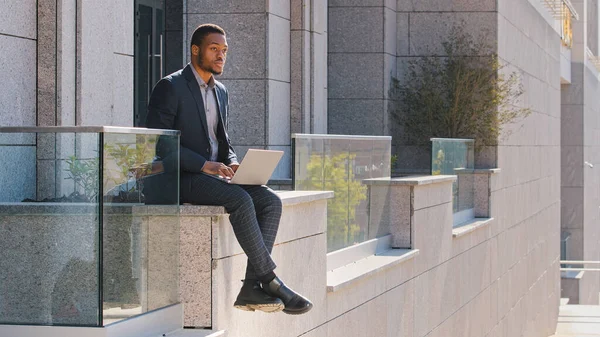 Przemyślany Etniczny Biznesmen Afroamerykanin Menedżer Freelancer Siedzi Zewnątrz Pisząc Laptopie — Zdjęcie stockowe