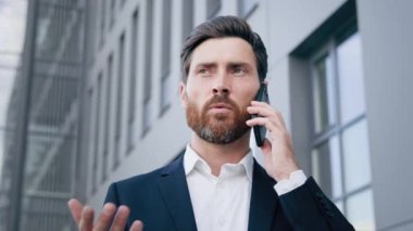 Yakın plan yakışıklı adam cep telefonuyla konuşuyor başarılı iş adamı lideri iş ortağı yönetici danışmanı uzaktan danışman müşteriye cep telefonuyla iletişim kurarak sipariş veriyor.